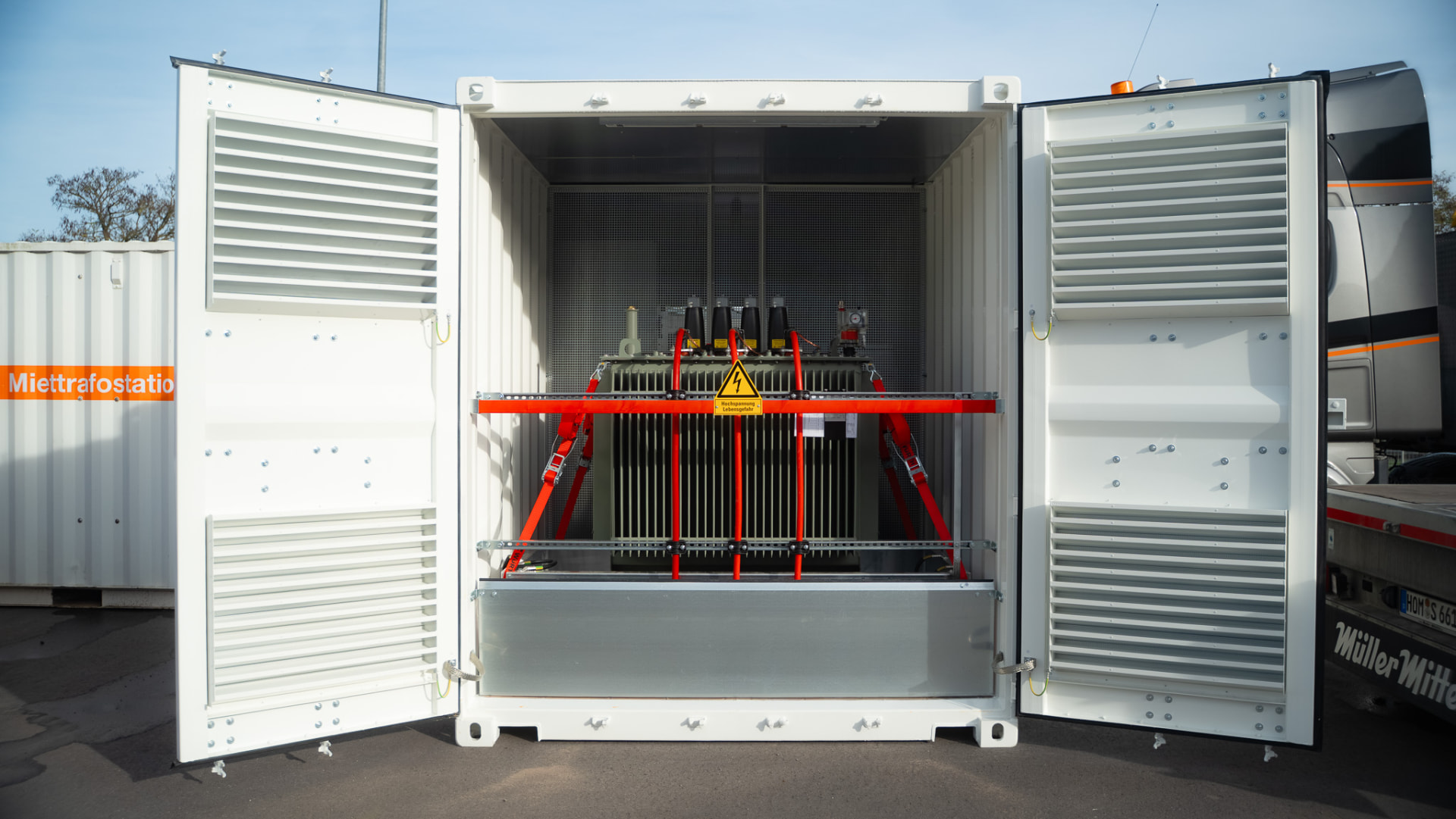 Mobile Miettrafostation in weißem Container mit geöffneten Türen